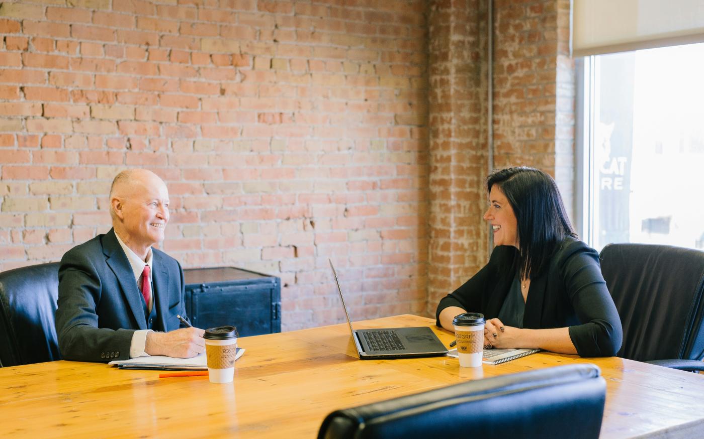 man and woman talking inside office by Amy Hirschi courtesy of Unsplash.